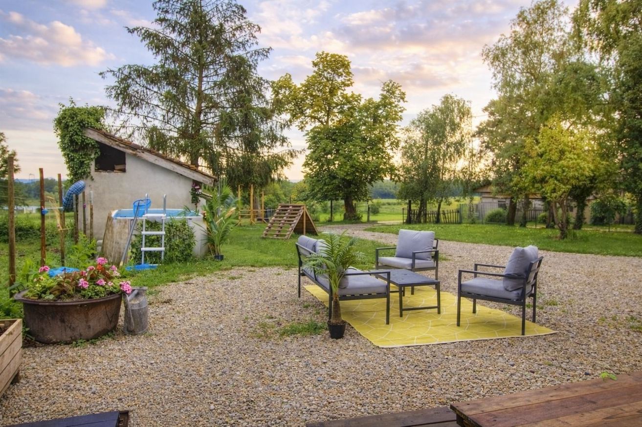Jardin avec piscine et salon extérieur au coucher de soleil – Gîte Les Pétillières